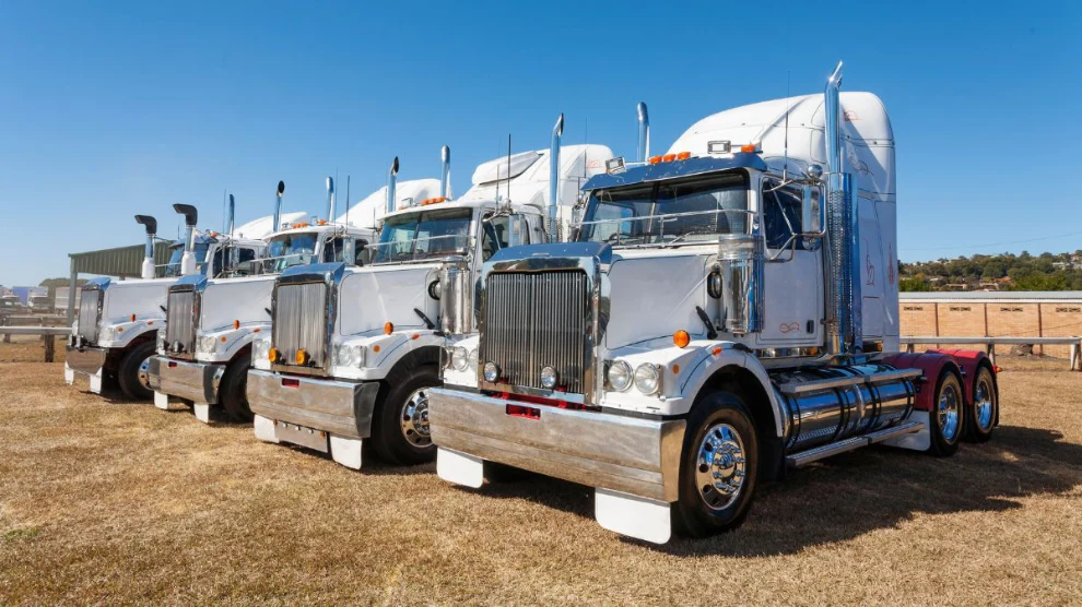 Row of trucks parked along side of the road.